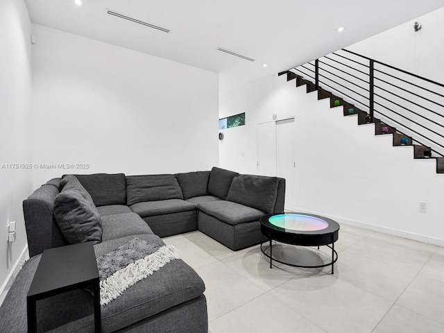 living area with light tile patterned floors, recessed lighting, visible vents, baseboards, and stairs