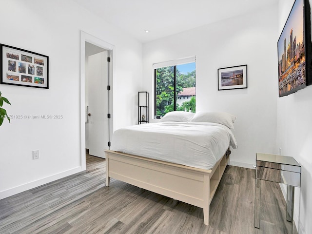 bedroom with baseboards and wood finished floors