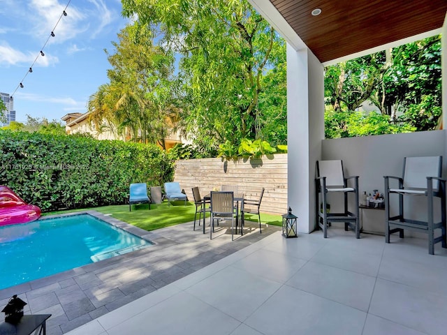 view of swimming pool featuring outdoor dining area, a patio area, a fenced backyard, and a fenced in pool