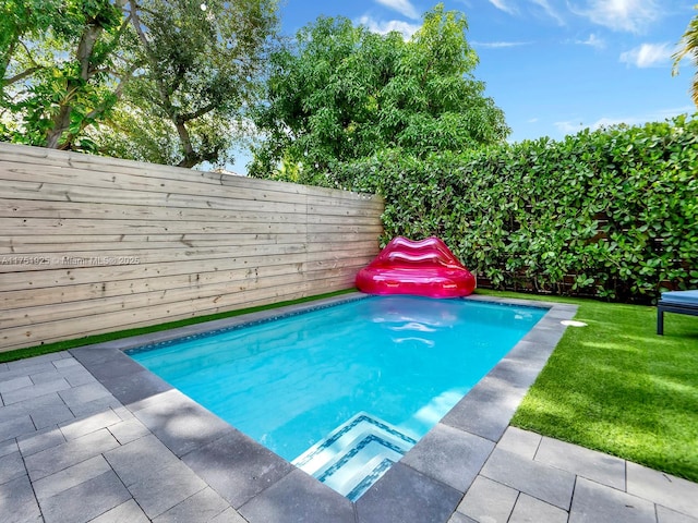 view of pool with a lawn and fence