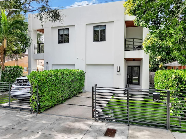 view of front of property featuring a fenced front yard, driveway, a garage, and stucco siding