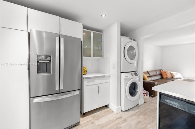 laundry room featuring stacked washer and dryer, light wood-type flooring, laundry area, and recessed lighting