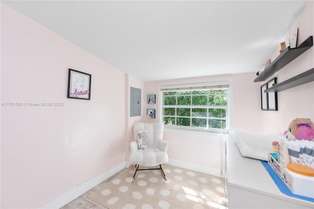 bedroom featuring electric panel and baseboards