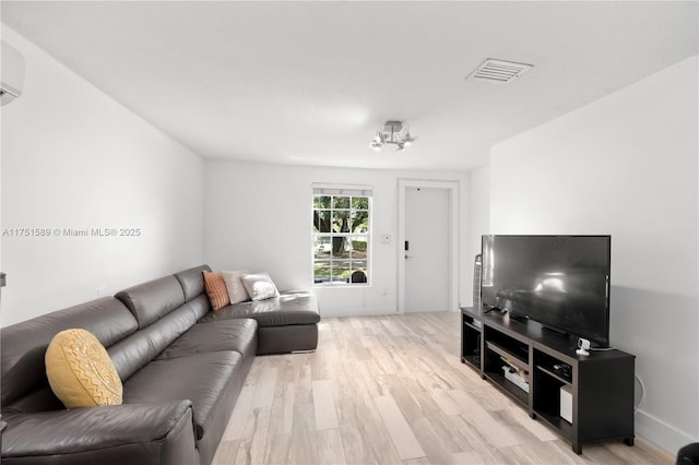 living area with light wood-style floors and visible vents