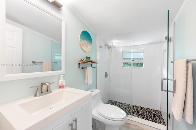 full bath with vanity, a shower stall, and toilet