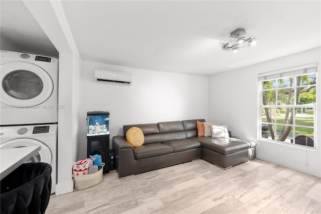 living room with a wall mounted AC, wood finished floors, and stacked washer and clothes dryer