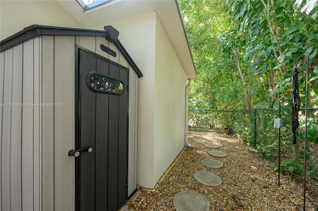 view of side of property featuring fence and an outbuilding