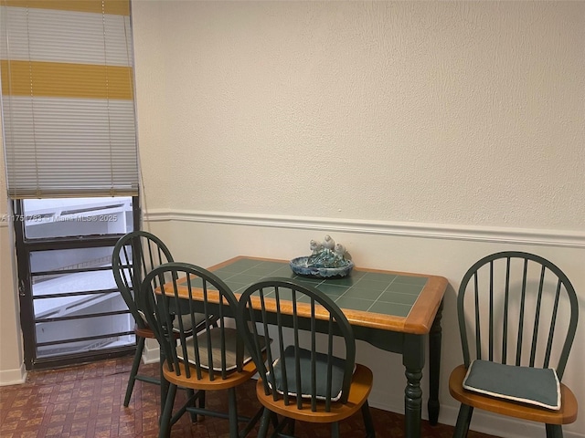 dining room with dark floors and wainscoting