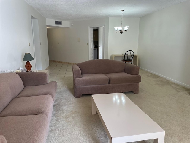 living area with visible vents, light colored carpet, an inviting chandelier, a textured ceiling, and baseboards