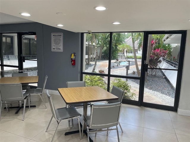 dining area with light tile patterned floors, baseboards, floor to ceiling windows, and recessed lighting