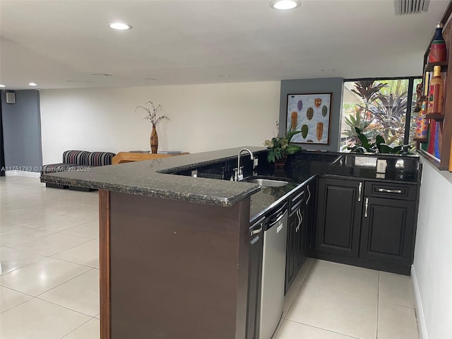 kitchen featuring visible vents, open floor plan, dark stone countertops, stainless steel dishwasher, and a sink