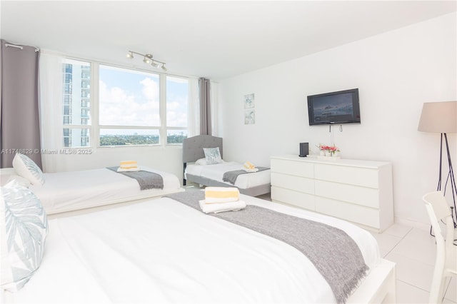 bedroom featuring light tile patterned flooring and track lighting