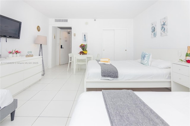 bedroom featuring a closet, light tile patterned flooring, and visible vents