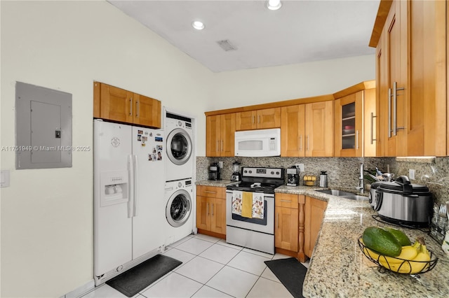 kitchen featuring white appliances, electric panel, glass insert cabinets, stacked washer / drying machine, and light stone countertops