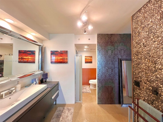 bathroom with vanity, tile patterned floors, toilet, and a shower with door