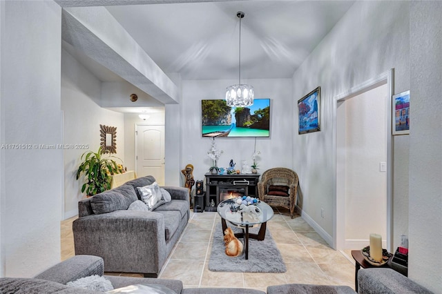 living room with a notable chandelier, baseboards, and light tile patterned floors