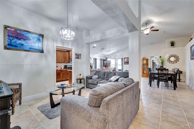 living room featuring high vaulted ceiling, ceiling fan with notable chandelier, visible vents, and light tile patterned floors