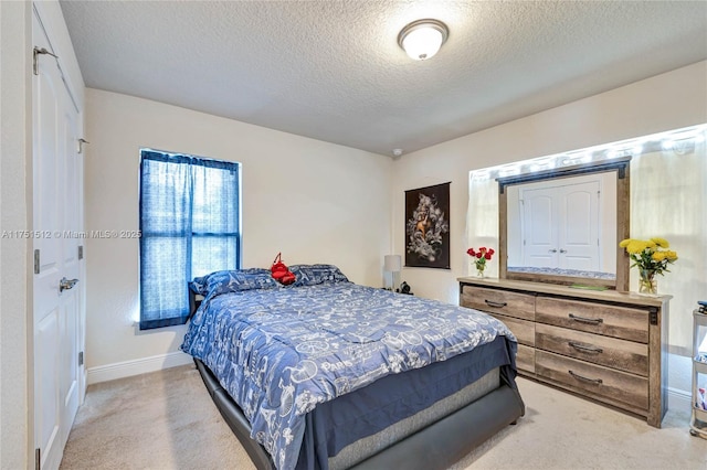 carpeted bedroom featuring baseboards and a textured ceiling