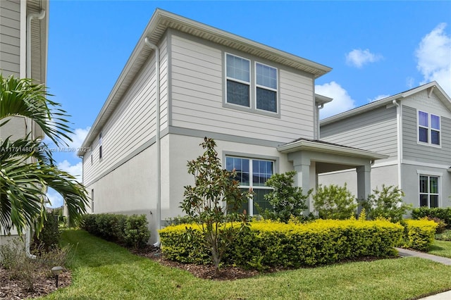 view of property exterior featuring a lawn and stucco siding