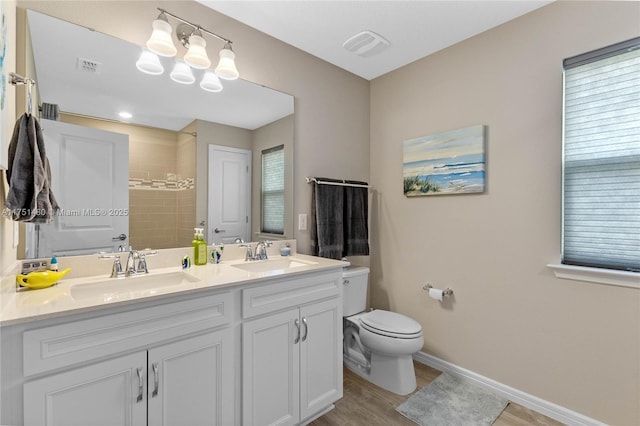 full bath with double vanity, baseboards, visible vents, and a sink