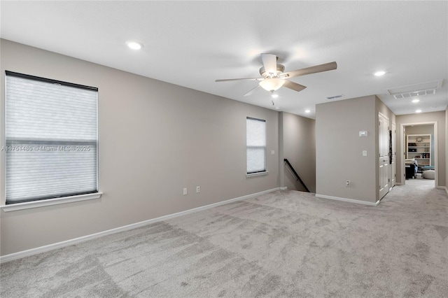 unfurnished room with light carpet, attic access, baseboards, visible vents, and recessed lighting