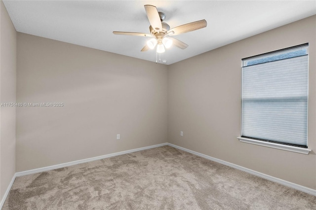 spare room featuring light carpet, baseboards, and a ceiling fan