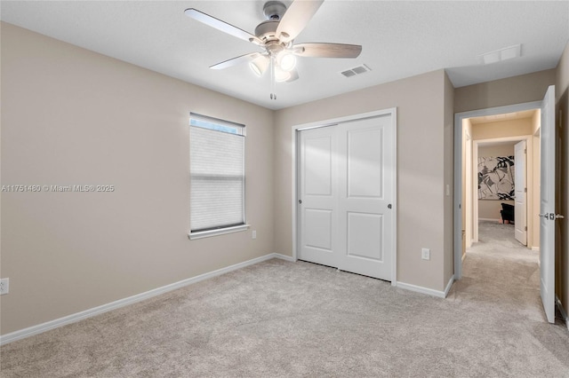 unfurnished bedroom with light carpet, a closet, visible vents, and baseboards