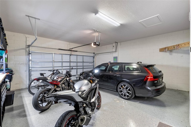 garage with concrete block wall and a garage door opener