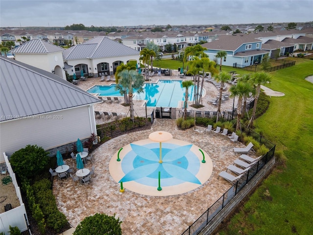 pool with a patio area, a residential view, fence, and a yard