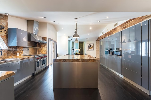 kitchen featuring a kitchen island, vaulted ceiling, a sink, double oven range, and wall chimney exhaust hood