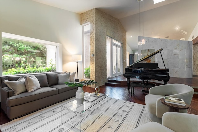 living area with a high ceiling, wood finished floors, and a healthy amount of sunlight