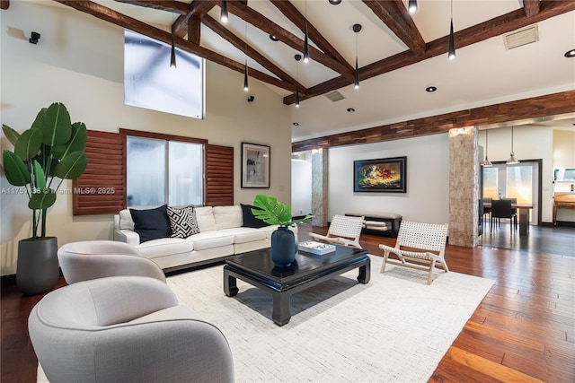 living area featuring hardwood / wood-style flooring, visible vents, high vaulted ceiling, and beamed ceiling