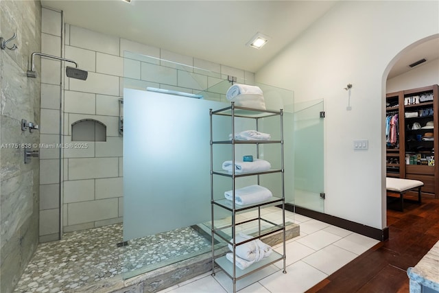 full bathroom featuring a walk in closet, visible vents, walk in shower, and wood finished floors