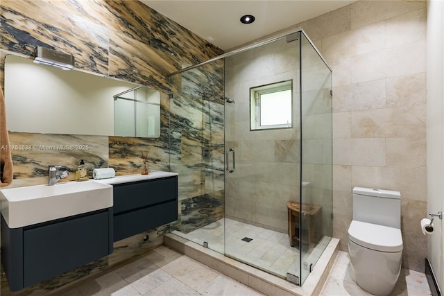 full bath with a stall shower, toilet, tile walls, and vanity