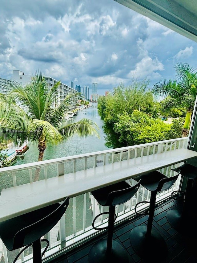 balcony with exterior bar, a water view, and a city view