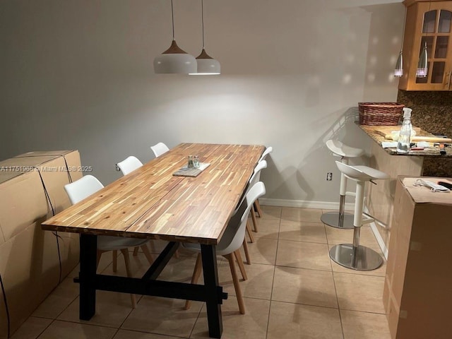 dining area featuring light tile patterned flooring and baseboards