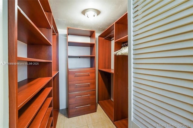 walk in closet with light tile patterned flooring