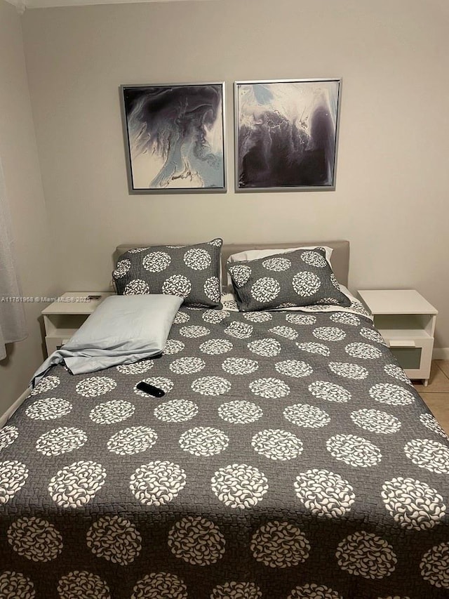 tiled bedroom featuring baseboards