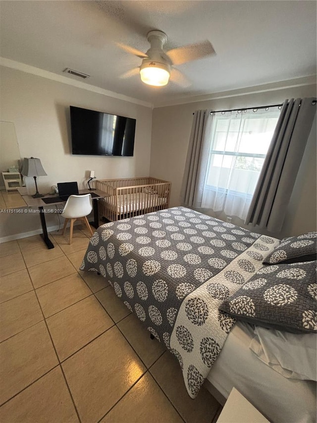 tiled bedroom with ceiling fan, ornamental molding, visible vents, and baseboards