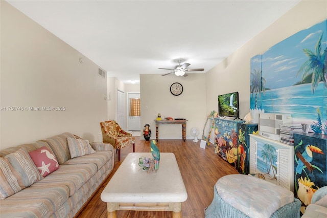 living area with ceiling fan, visible vents, and wood finished floors