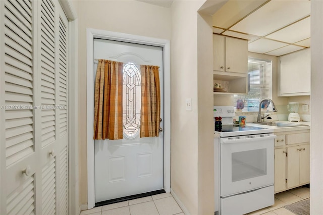 kitchen featuring open shelves, light tile patterned floors, light countertops, white electric range, and a sink