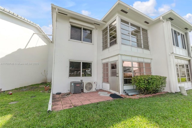 back of property featuring a lawn, a patio, fence, ac unit, and stucco siding