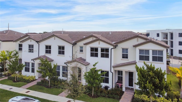 view of front facade featuring stucco siding and a tiled roof