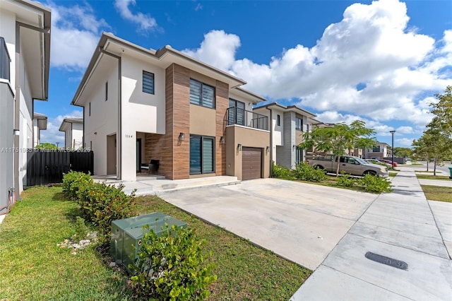 contemporary house featuring a garage, concrete driveway, a residential view, and stucco siding