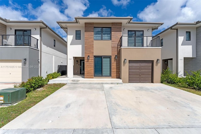 view of front of home with a garage, concrete driveway, and stucco siding