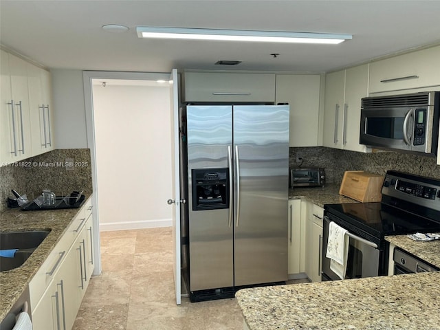 2025 Brickell Ave Unit 901, Miami, FL 33129 - kitchen featuring stainless steel appliances, backsplash, light stone countertops, a sink, and white cabinets