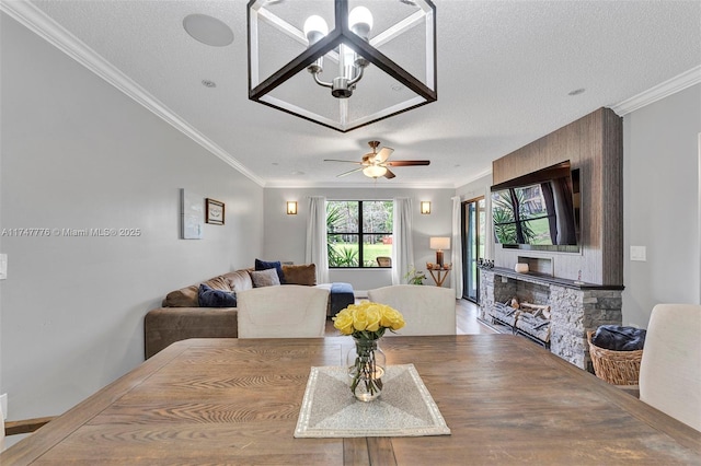 dining room featuring ornamental molding, ceiling fan, and a textured ceiling