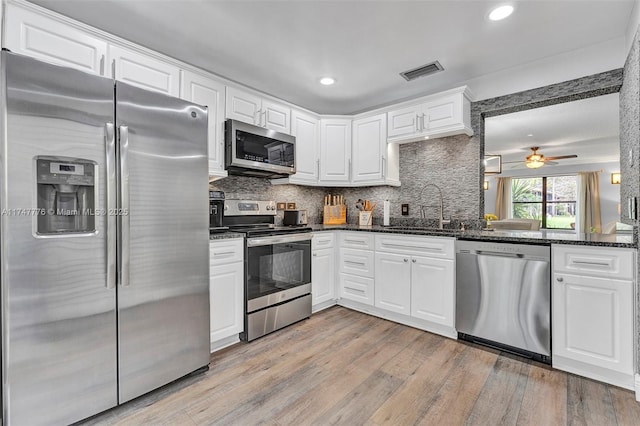 kitchen featuring a sink, visible vents, light wood-style floors, appliances with stainless steel finishes, and tasteful backsplash