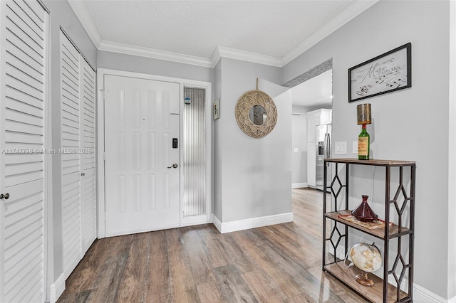 foyer entrance featuring baseboards, ornamental molding, and wood finished floors