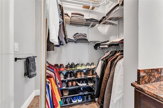spacious closet featuring stone finish flooring